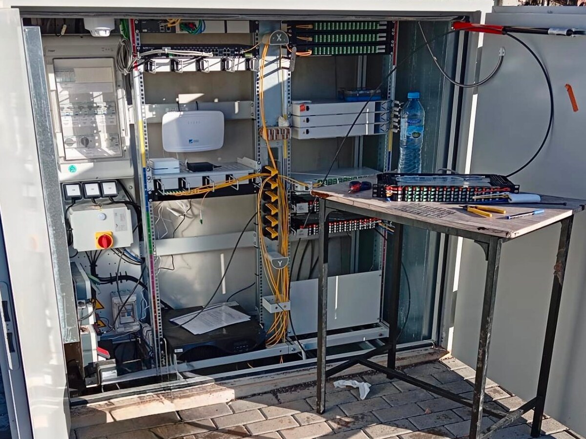 Armario técnico de red de gran formato abierto con paneles de conexión y cableado de fibra.